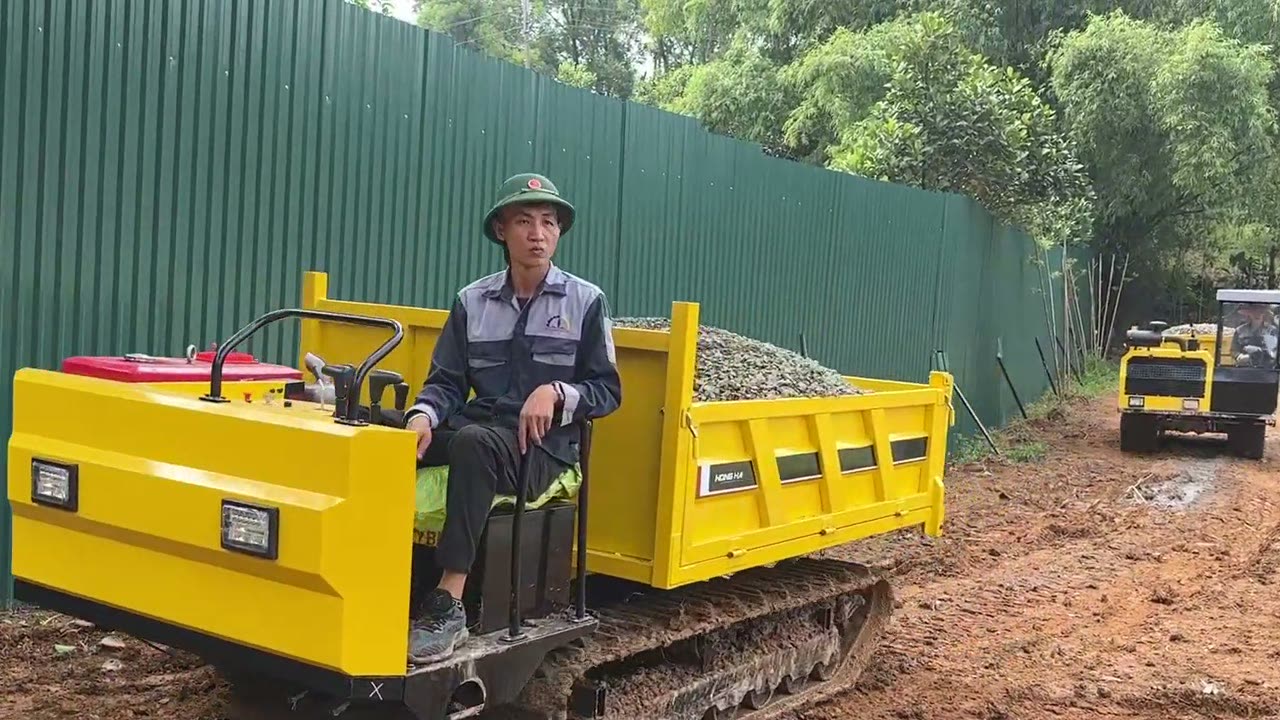 Người lái ngồi ghế xe rùa bánh xích 3 tấn chở đầy đá dăm