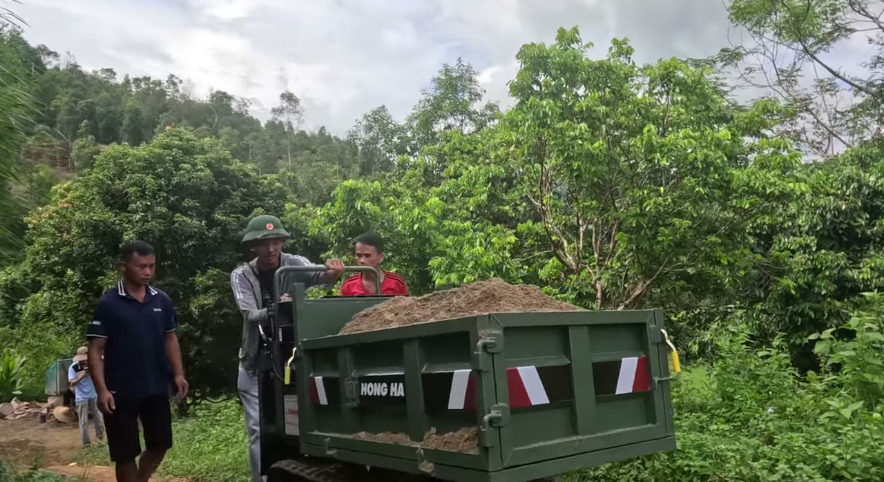 Xe rùa bánh xích 0,8 tấn chở đầy thùng đất trong vườn đồi