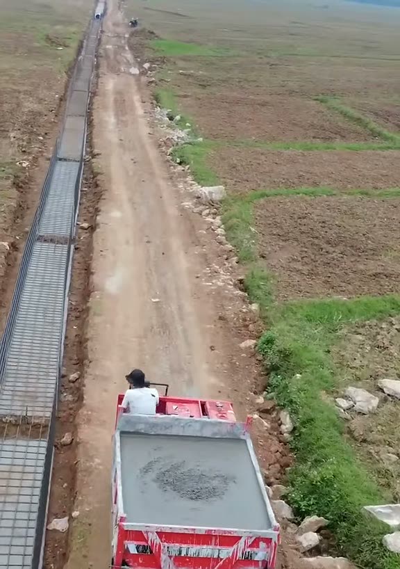 Xe rùa bánh xích chở bê tông dọc bờ kè đang làm